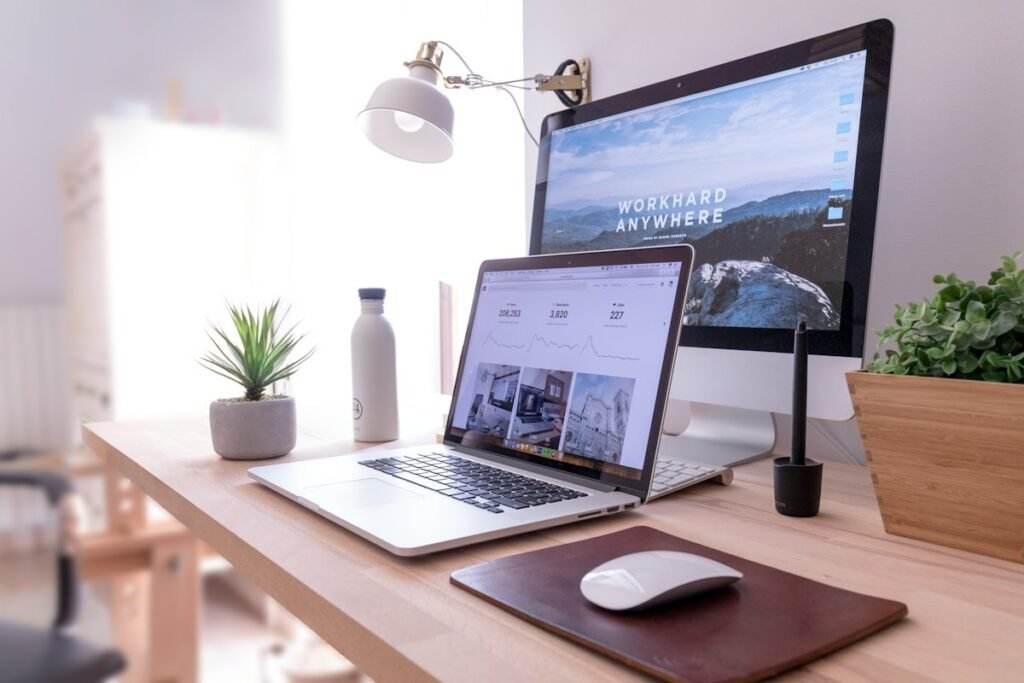 Computer and laptop on a bright workspace
