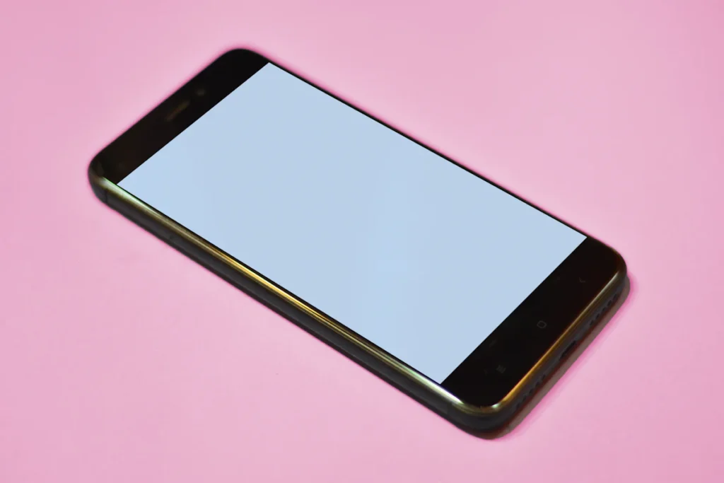 A smartphone with a blank screen on a colored background
