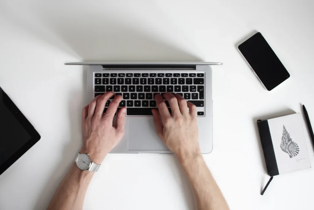 Overhead view of a laptop and notebook workspace